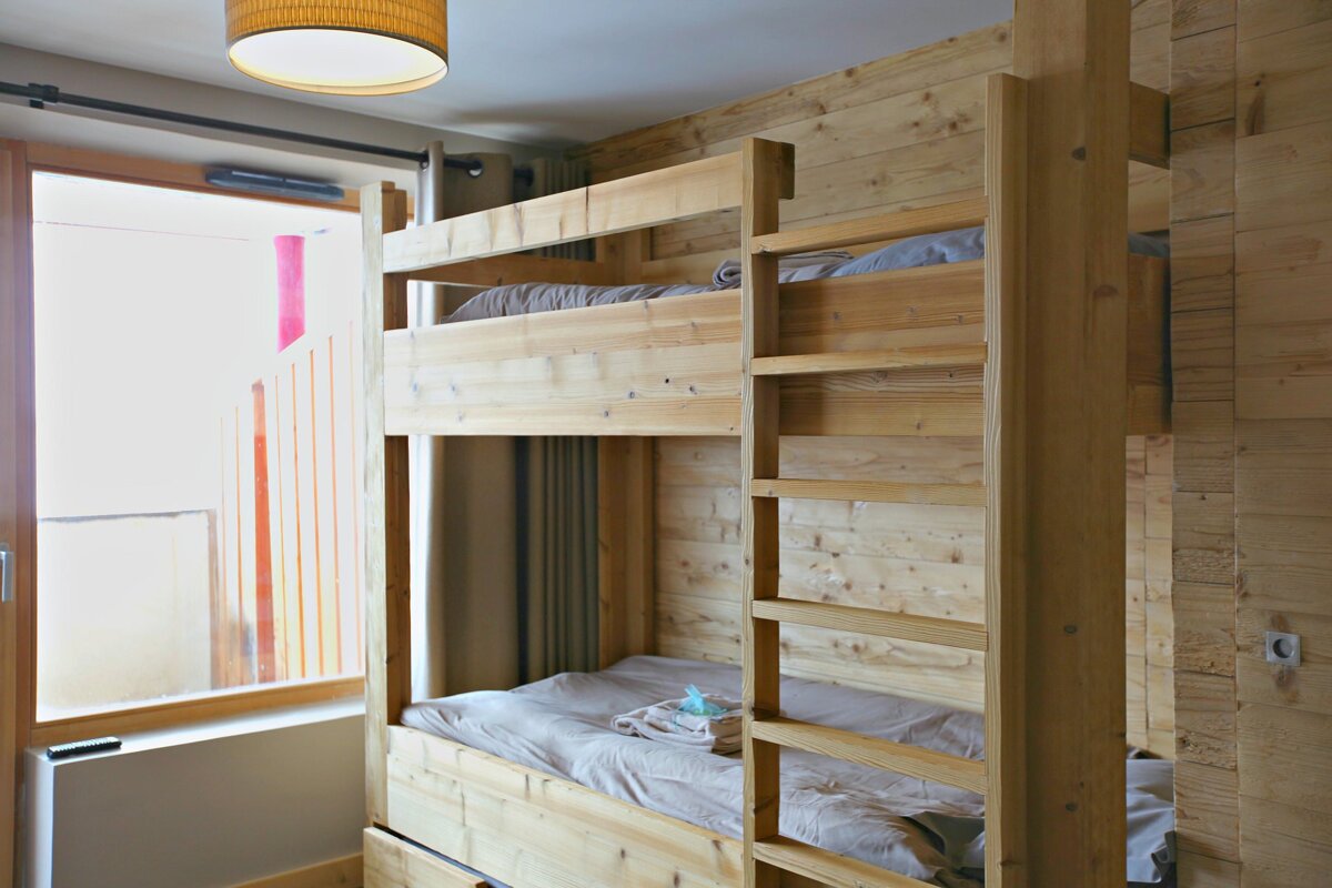 A wooden bunk bed with a drawer underneath it