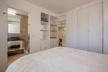 A bedroom with a large bed and a window