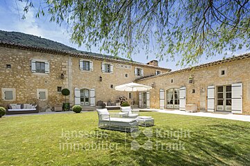 A large stone building with white shutters is for sale by jansson immobilier