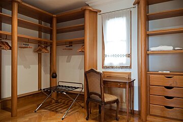 A walk in closet with a chair and a desk
