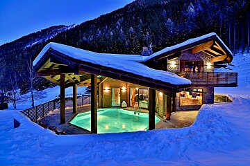A snowy house with a swimming pool in front of it