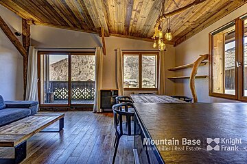 A living room with a table and chairs and a sign that says mountain base