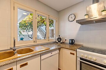 A kitchen with a clock on the wall that shows the time as 4:20