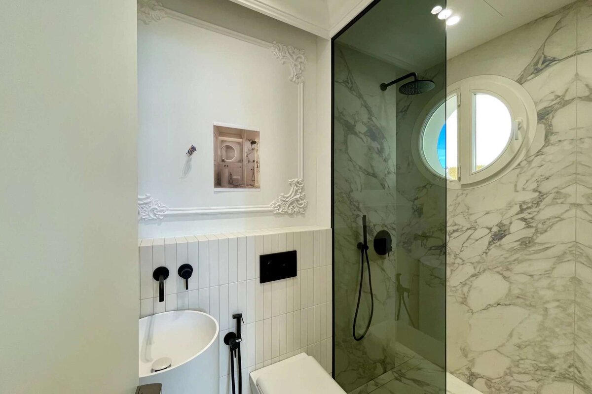 A bathroom with marble walls and a toilet and sink