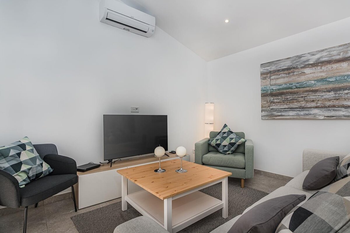 A living room with two chairs and a flat screen tv