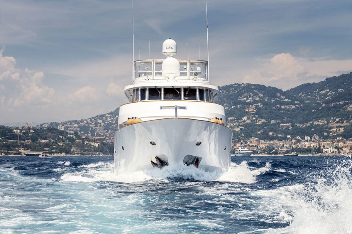 A white boat with a radar on the top of it