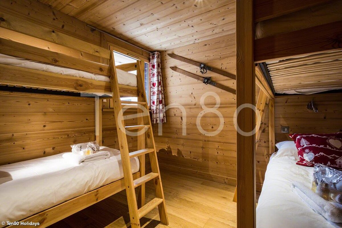 A bedroom with bunk beds and a sign that says ten80 holidays