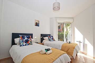 A bedroom with two beds and a sliding glass door