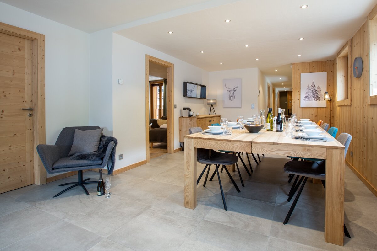 A dining room with a long wooden table and chairs