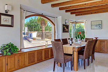 A dining room with a table and chairs and a window