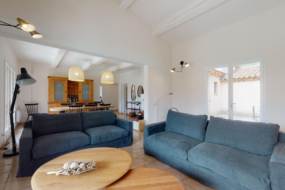 A living room with a blue couch and a wooden table