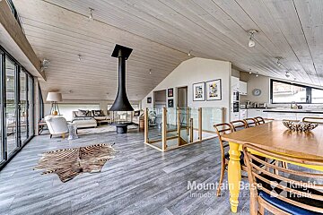 A living room with a dining table and chairs and a sign that says mountain base
