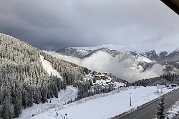 A snowy mountain landscape with a road in the foreground
