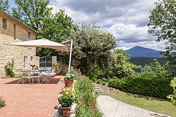 A patio with a table and chairs under an umbrella