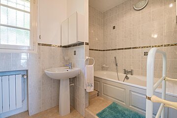 A bathroom with a sink and a bathtub with a towel that says lg on it