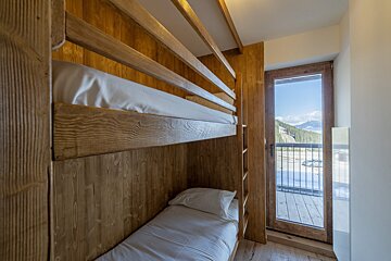 A bunk bed with a view of the mountains behind it