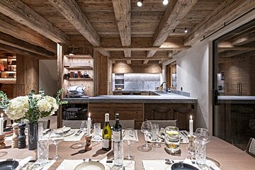 A bottle of wine sits on a table in a kitchen