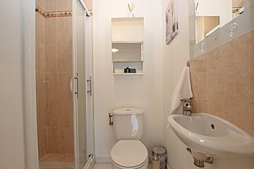 A bathroom with a toilet a sink and a shower
