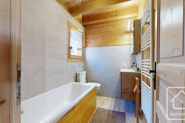 A bathroom with a bathtub a toilet and a towel rack