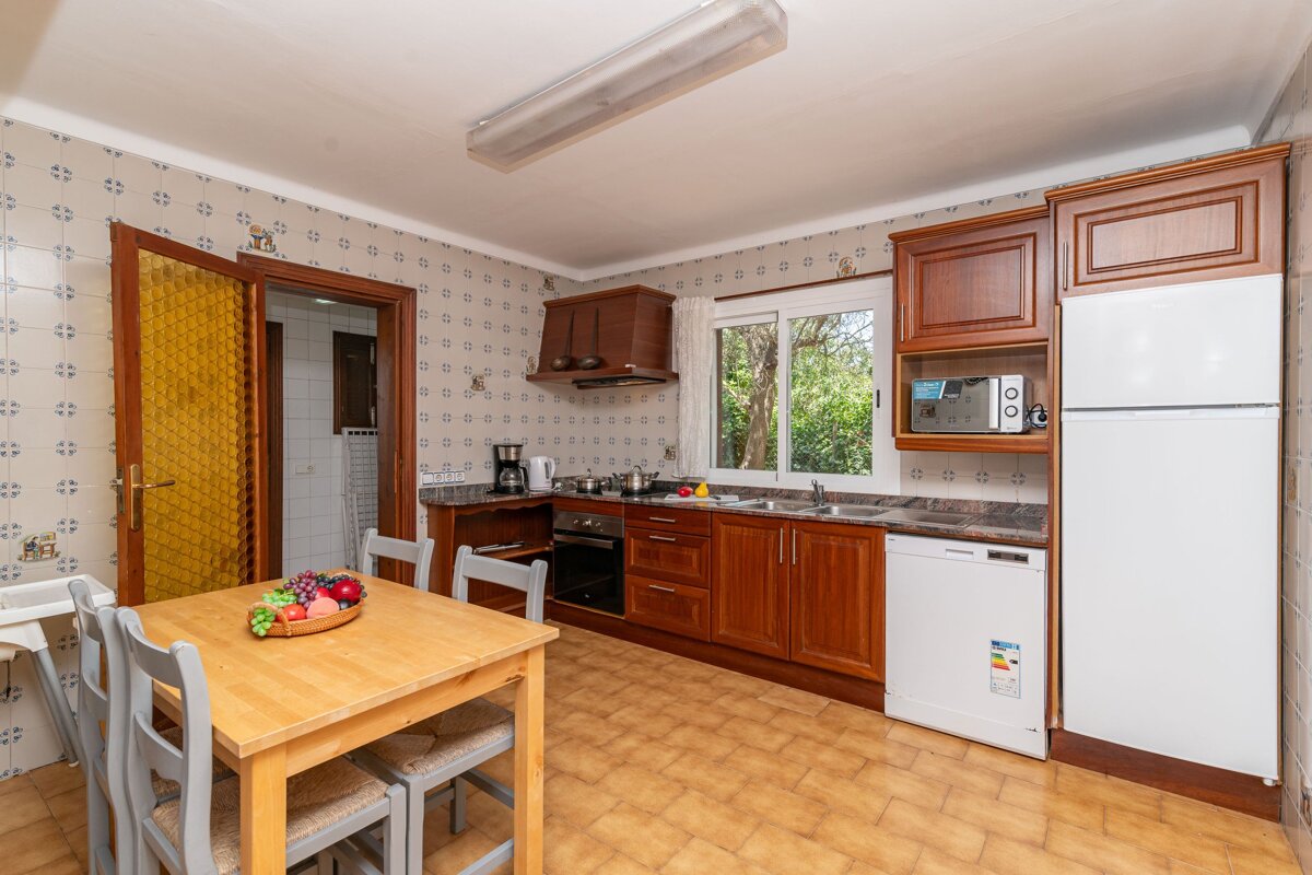 A kitchen with a white refrigerator and a microwave