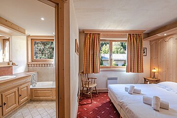 A bedroom with a king size bed and a chair
