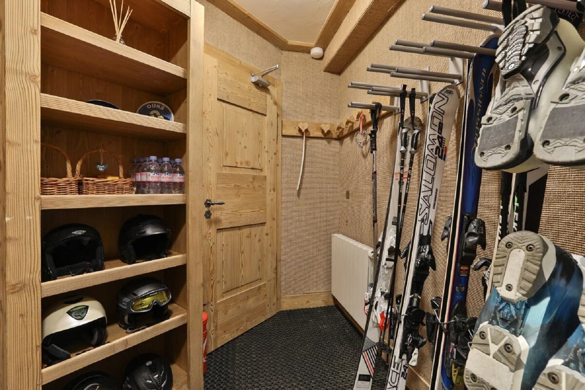 A salomon ski is hanging on a rack in a closet