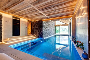 A large indoor swimming pool with a wooden ceiling