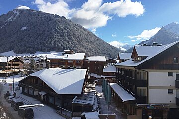 Snow covered buildings in a ski resort with a sign that says