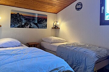 A bedroom with two beds and a picture on the wall that says