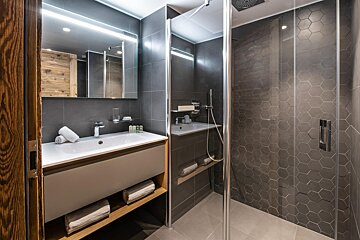 A bathroom with a walk in shower and a sink