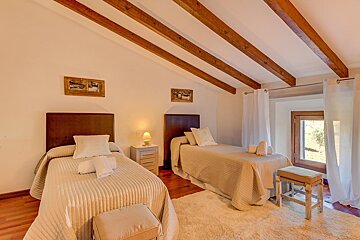 A bedroom with two twin beds and a window