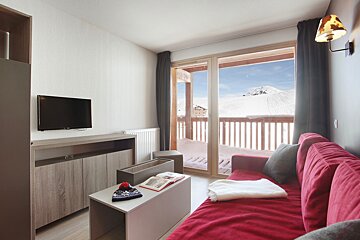A living room with a red couch and a flat screen tv