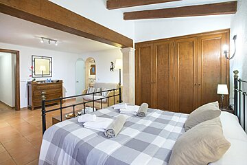 A bedroom with a large bed and a dresser