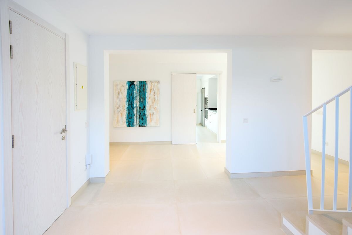 A hallway with stairs and a painting on the wall