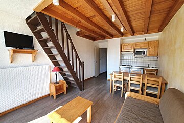 A living room with a staircase leading up to the second floor