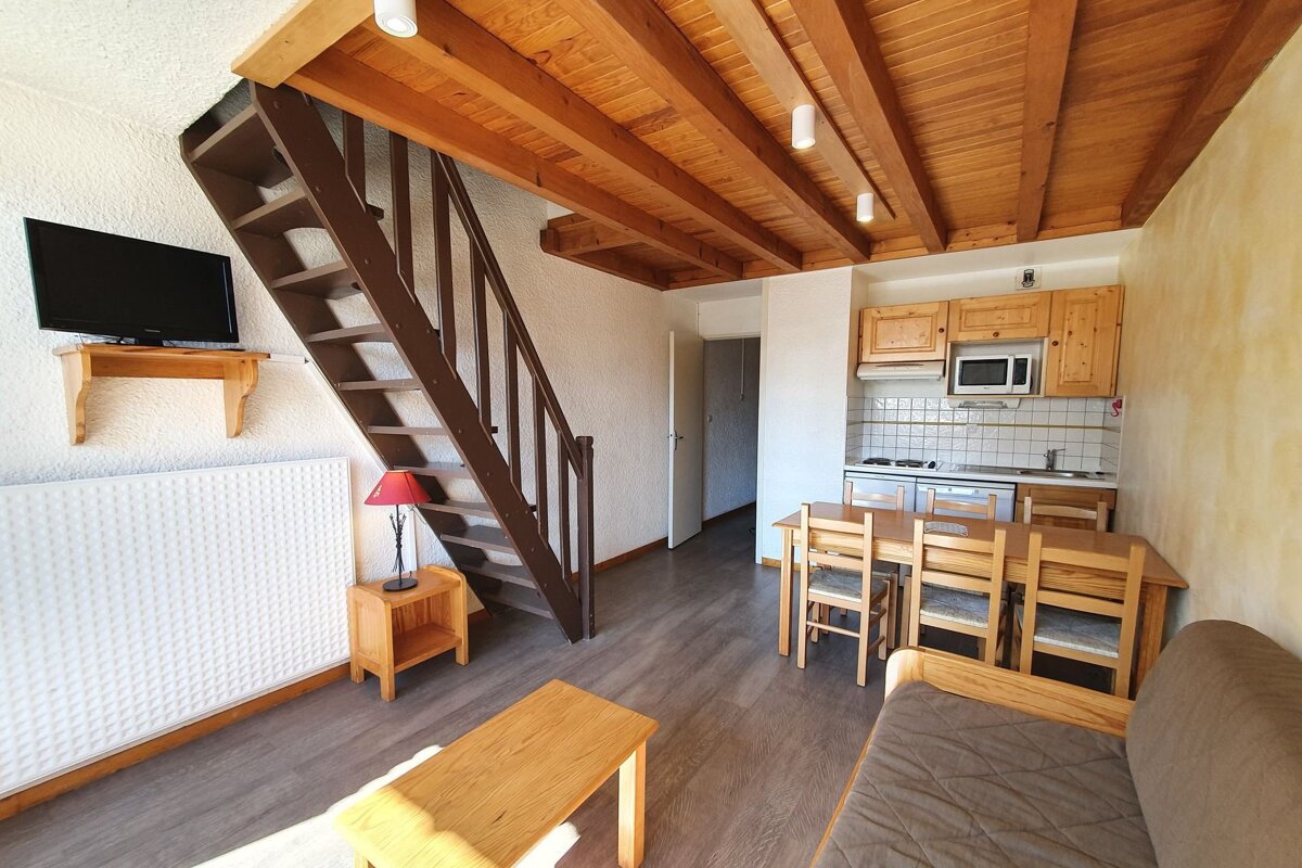 A living room with a staircase leading up to the second floor