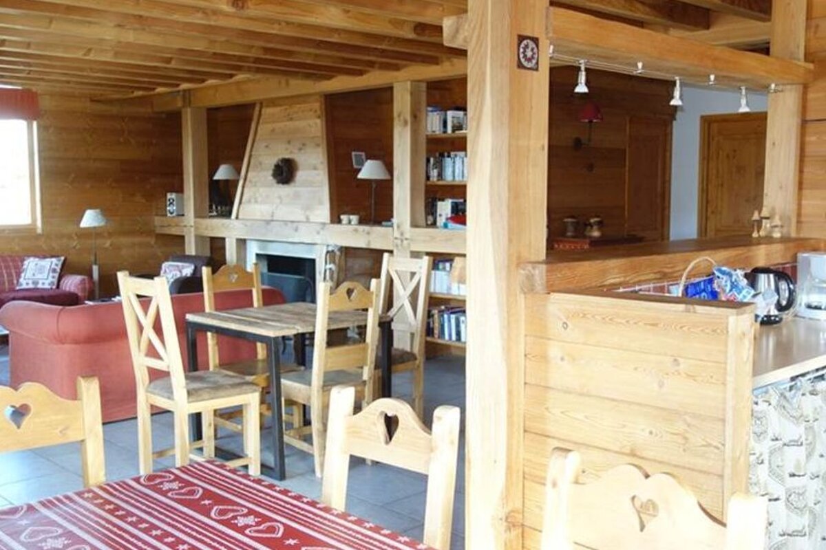 A wooden room with a table and chairs and a coffee maker