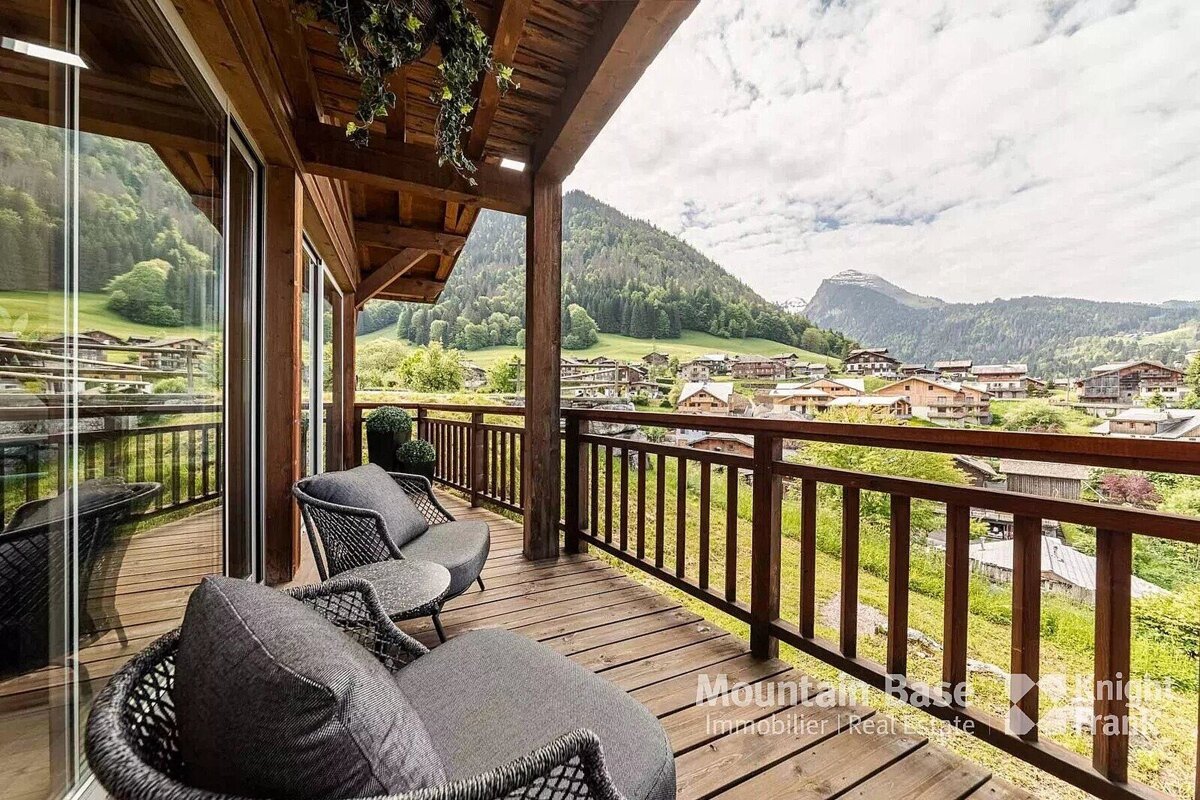 A balcony with a view of the mountains and a sign that says mountain base