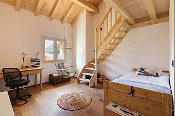 A bedroom with a wooden staircase and a hammock