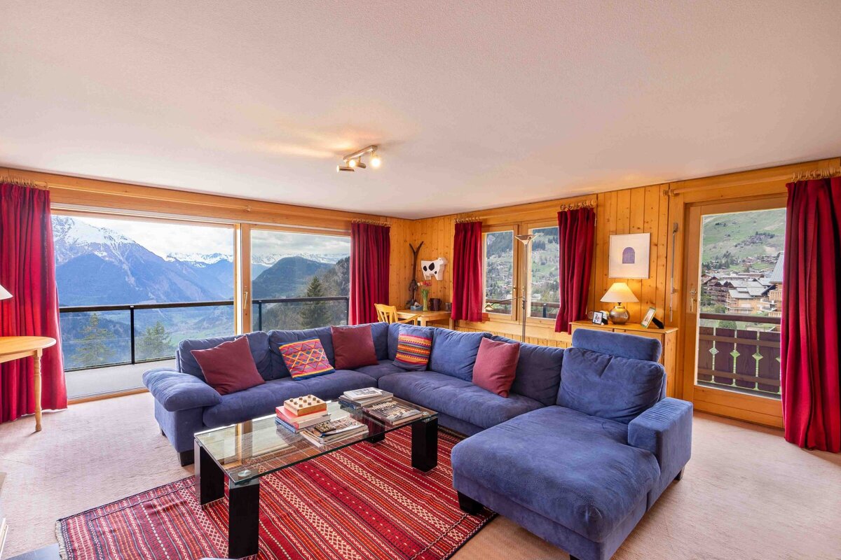 A living room with a blue couch and a glass coffee table