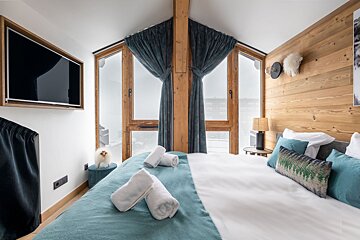 A bedroom with a rental designer logo on the corner