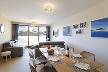 A dining table with a bottle of red wine on it