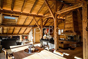 A living room with a wooden table and chairs and a fireplace