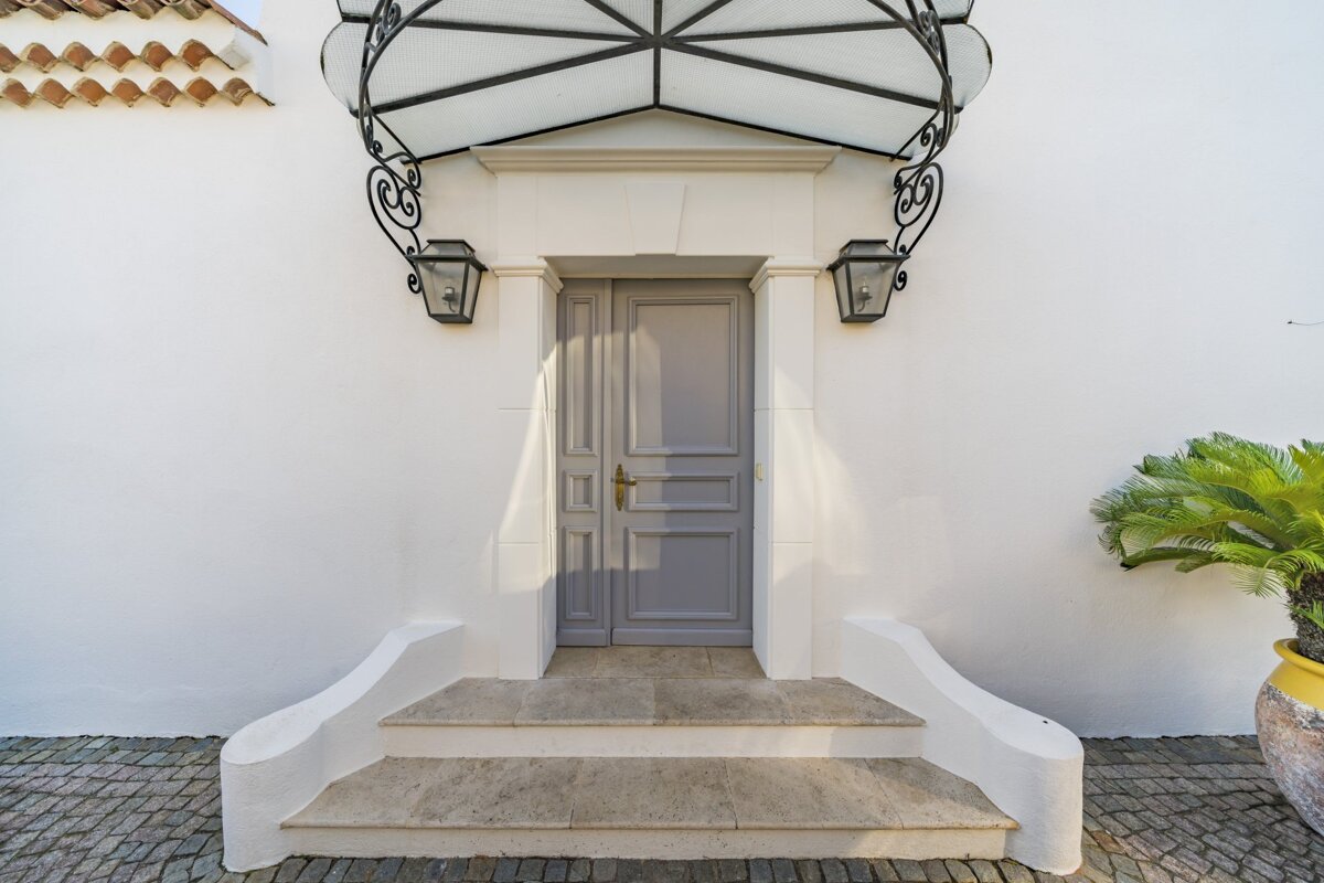 A white building with a gray door and steps