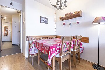 A dining room with a table and chairs and a lamp