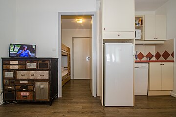 A room with a dresser and a refrigerator with a sticker on it that says ' a ' on it