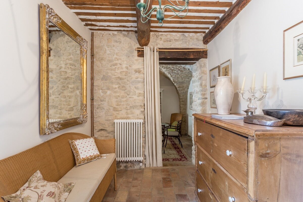 A hallway with a wooden dresser and a mirror on the wall