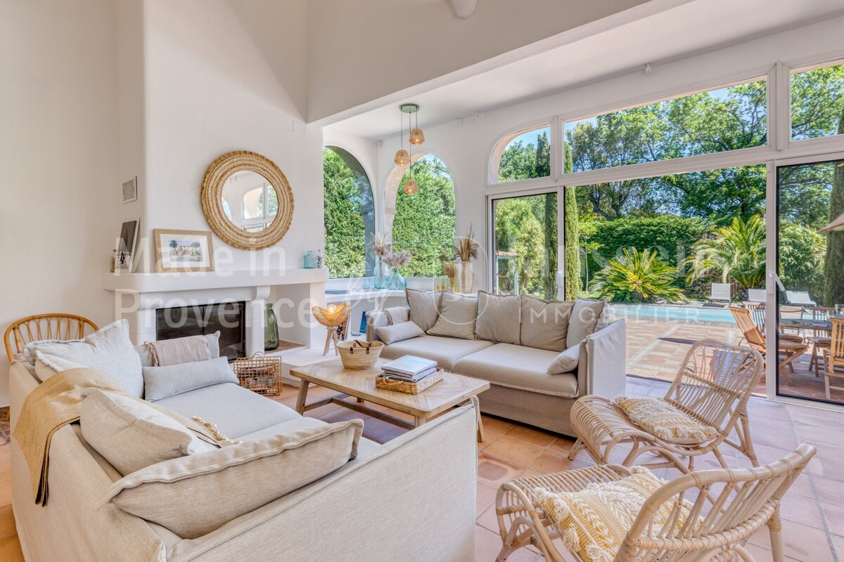 A living room with a couch and wicker chairs and a sign that says provence immobilier