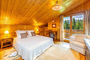 A bedroom with a king size bed and a chair