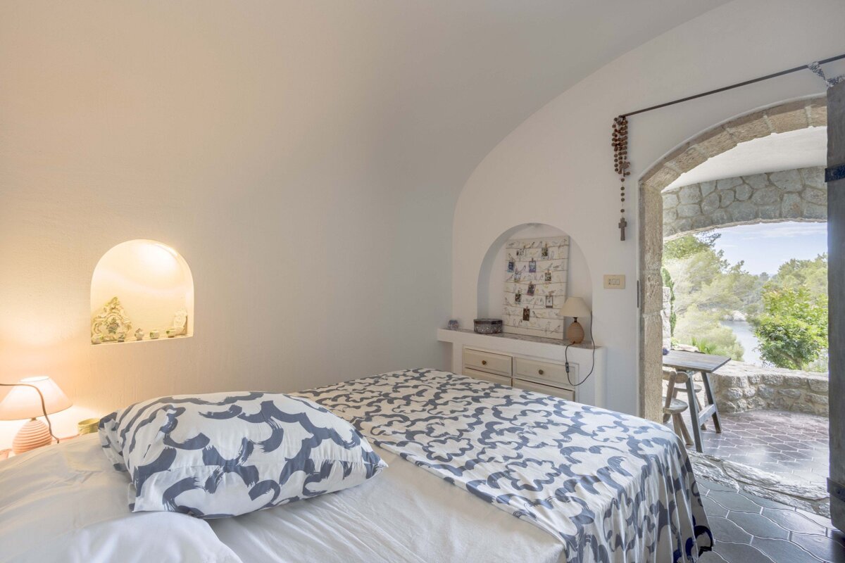A bed with a blue and white patterned blanket